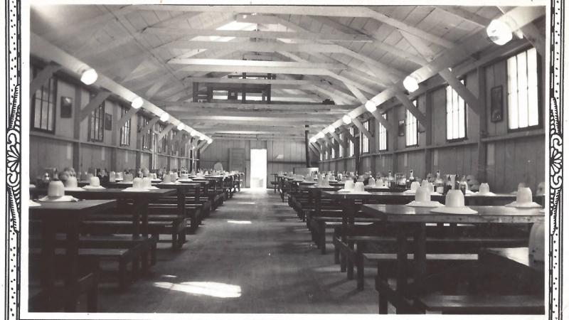 A mess hall with the tables set for the enrollees of the Civilian Conservation Corps. Some were not this fancy.