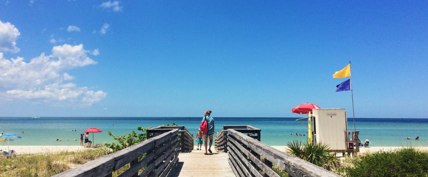 Giel walking toward the beach on a boardwalk